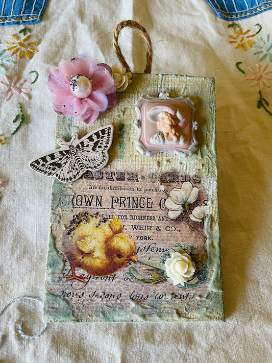 Shabby chic style wall decor with mixed media art collage using decoupage paper, a porcelain jewelry piece and paper flowers