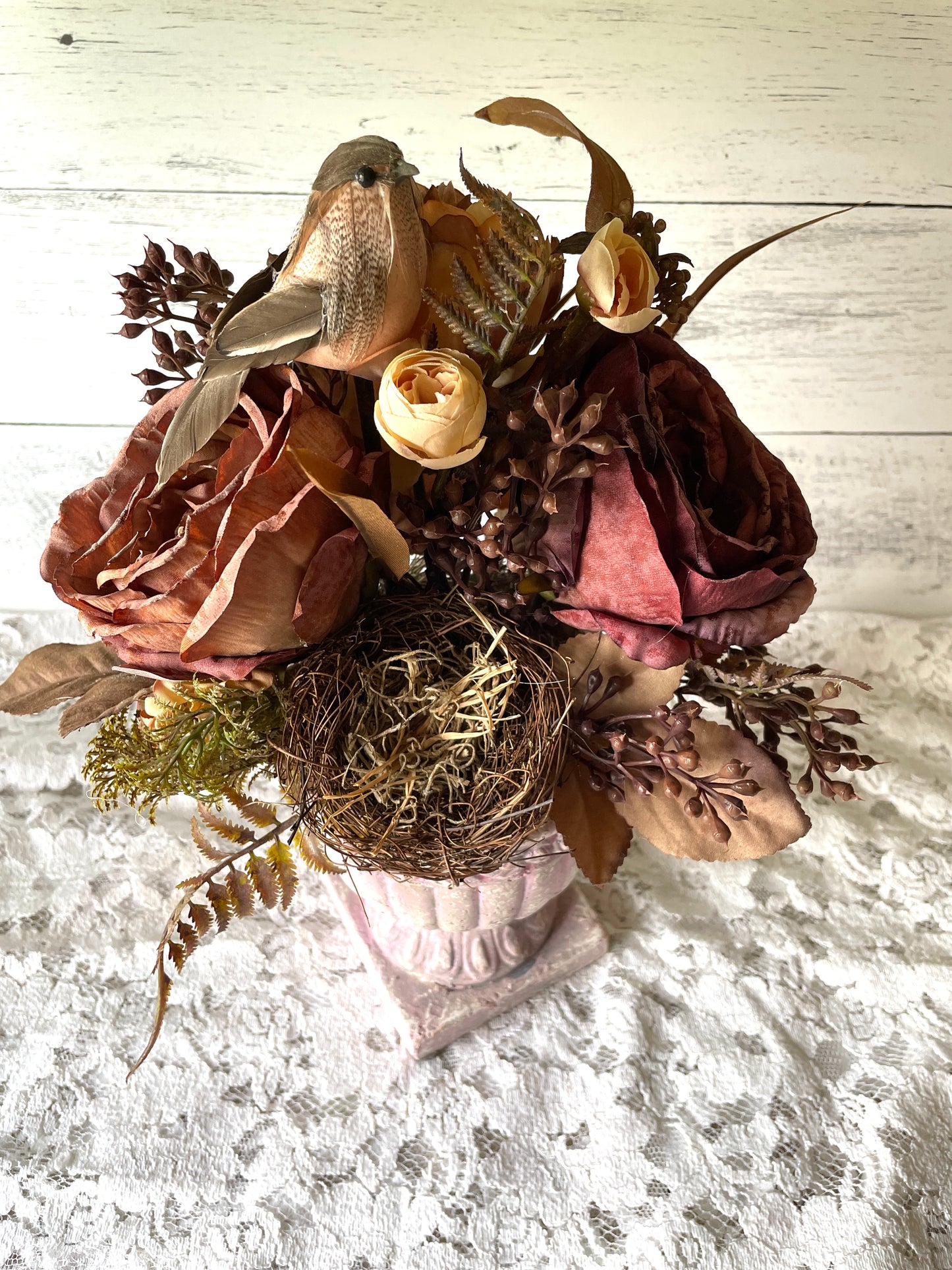 fall floral arrangement with dark red roses in a clay urn por