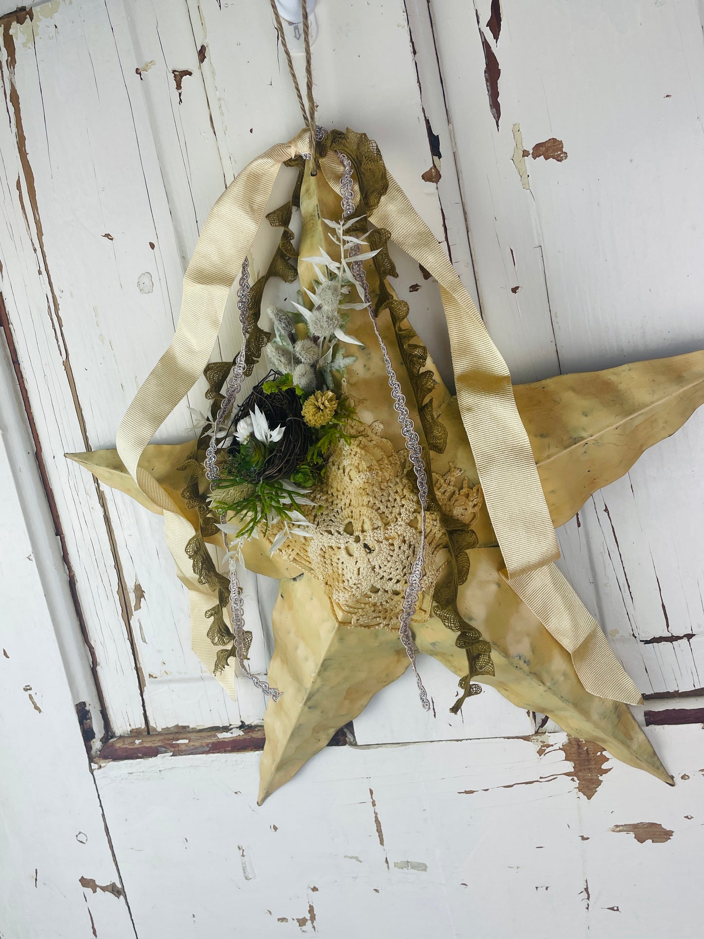 Rustic star wall hanging with dried flowers and birds nest