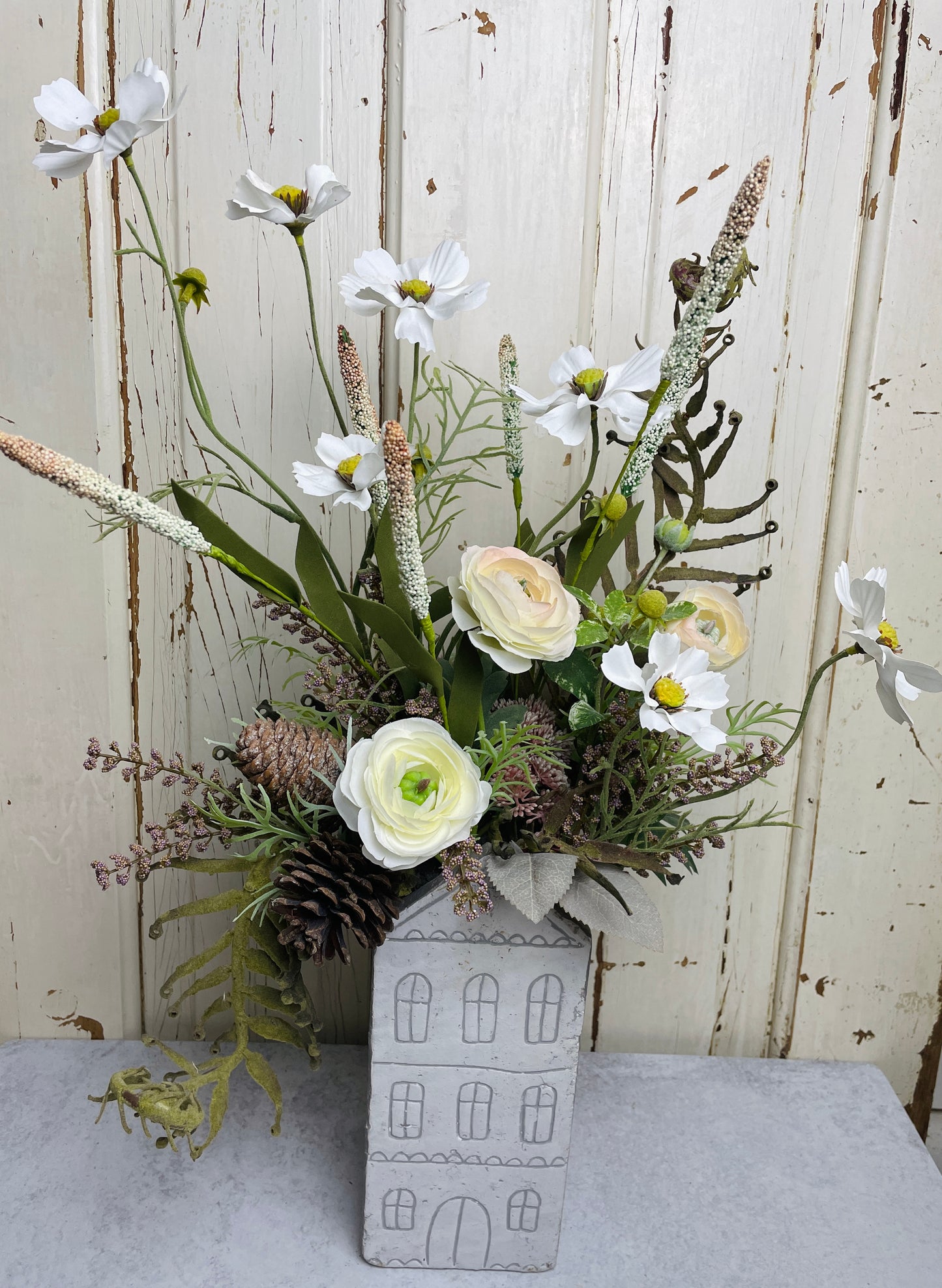 Neutral floral arangement in ceramic house planter