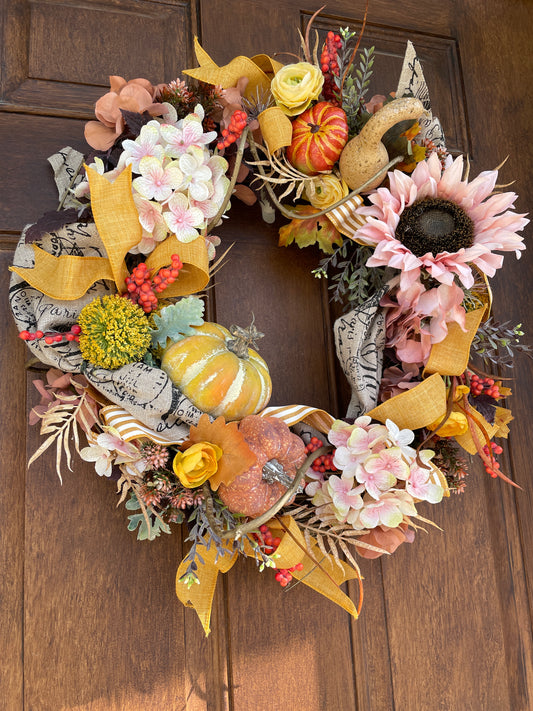 large fall floral door wreath with pink sunflowers and orange pumpkins