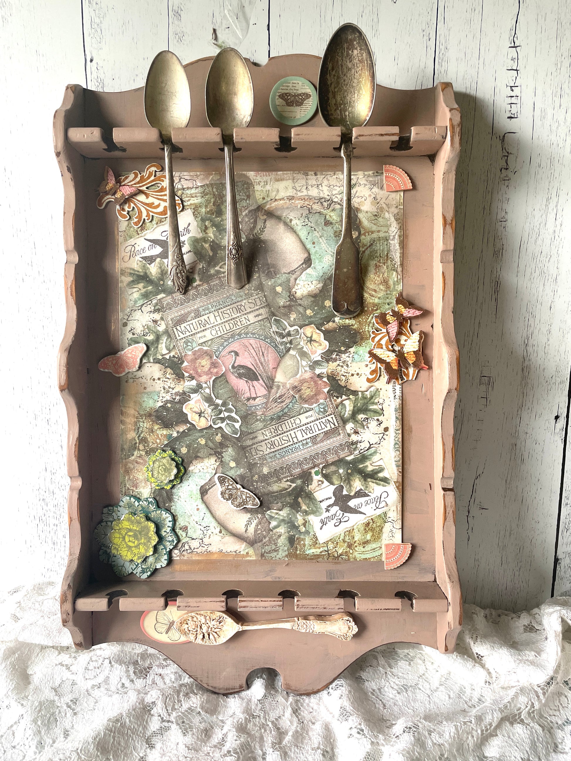 Upccled vintage spoon holder for wall with art assemblage of vintage silver spoons, collage, and clay in a floral theme