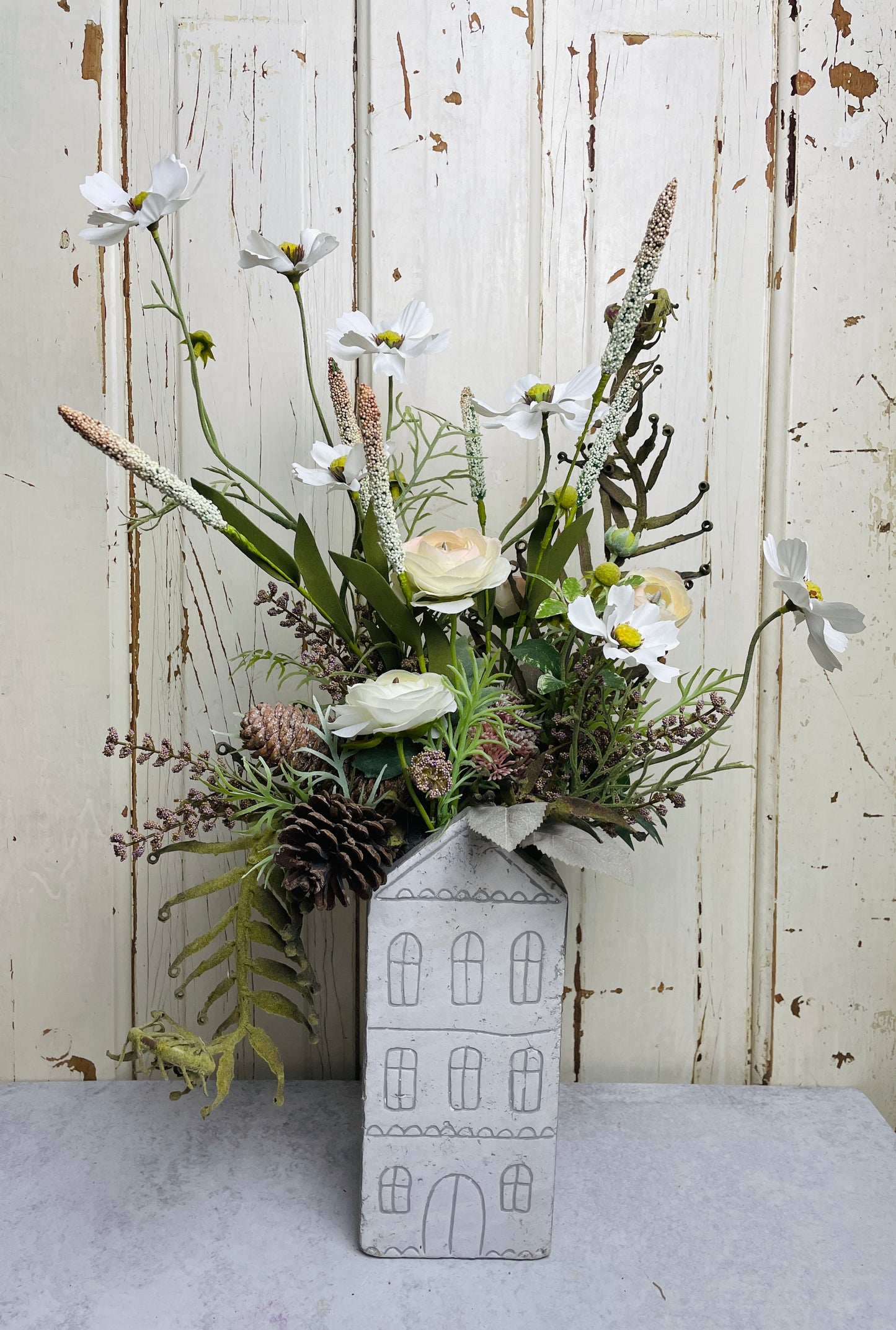 Neutral floral arangement in ceramic house planter