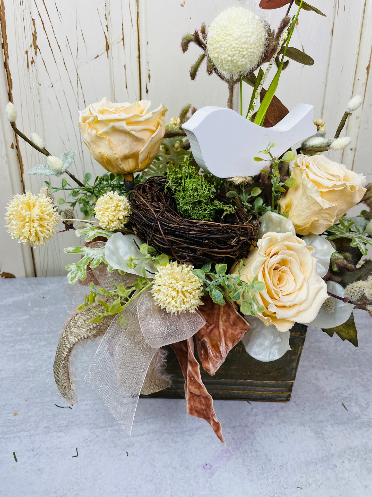 Dried floral arrangement with roses and birds nest